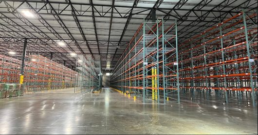 Long pallet rack rows with wire decking and reduced-width service aisles